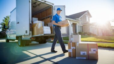 Camion de livraison déchargeant des colis devant une maison