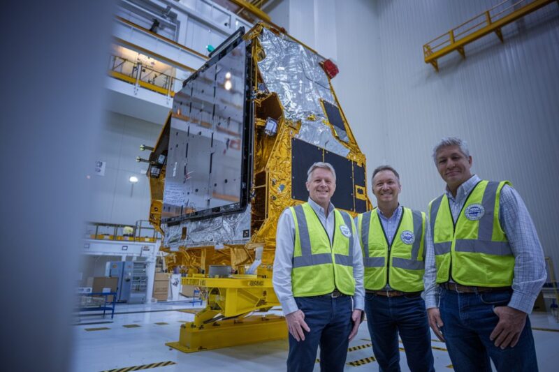 Des ing&eacute;nieurs observent un satellite en cours d&rsquo;assemblage dans une salle blanche